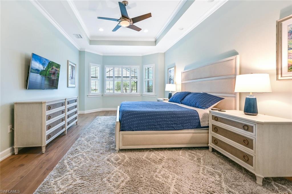 4909 Andros Drive Naples, FL 34113 - Photo 12 of 33 a spacious bedroom with a bed and a chandelier