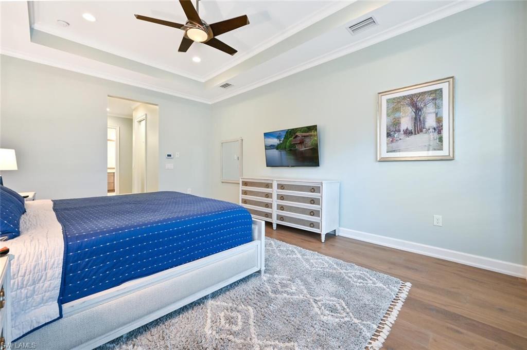 4909 Andros Drive Naples, FL 34113 - Photo 13 of 33 a bedroom with a bed and a chandelier