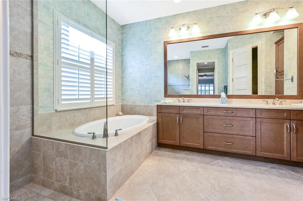4909 Andros Drive Naples, FL 34113 - Photo 14 of 33 a spacious bathroom with a tub sink and mirror