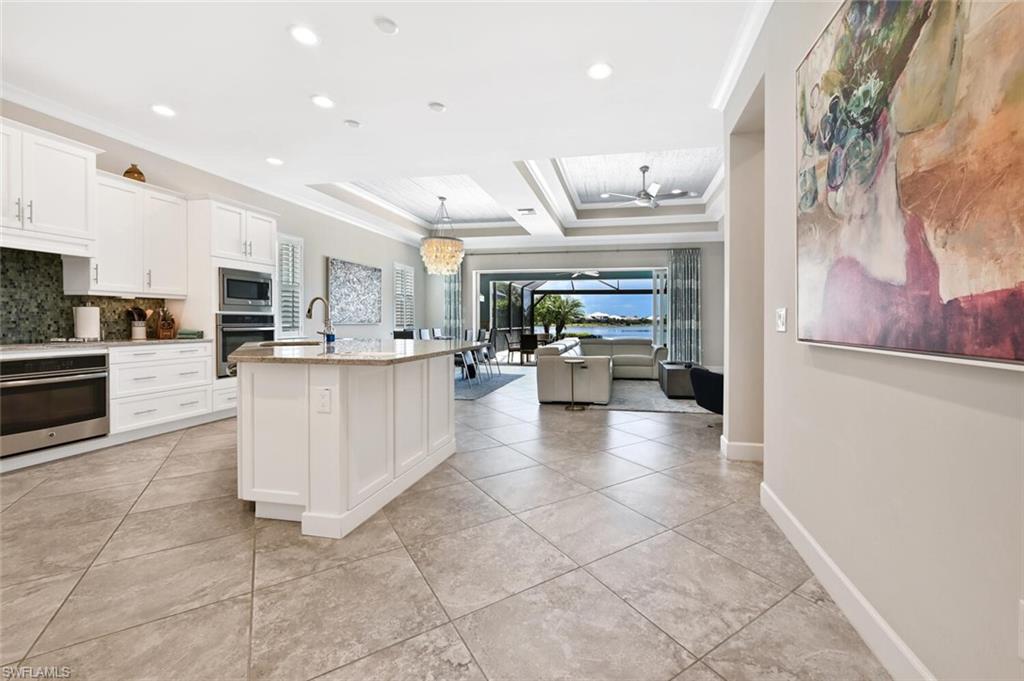 4909 Andros Drive Naples, FL 34113 - Photo 4 of 33 a view of a kitchen with kitchen island stainless steel appliances refrigerator stove microwave and cabinets