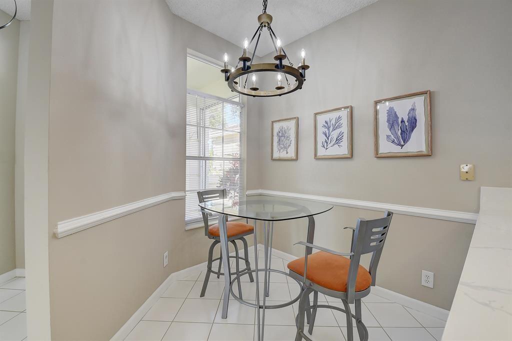 7769 Mansfield Hollow Road Delray Beach, FL 33446 - Photo 12 of 18 a view of a dining room with furniture and chandelier