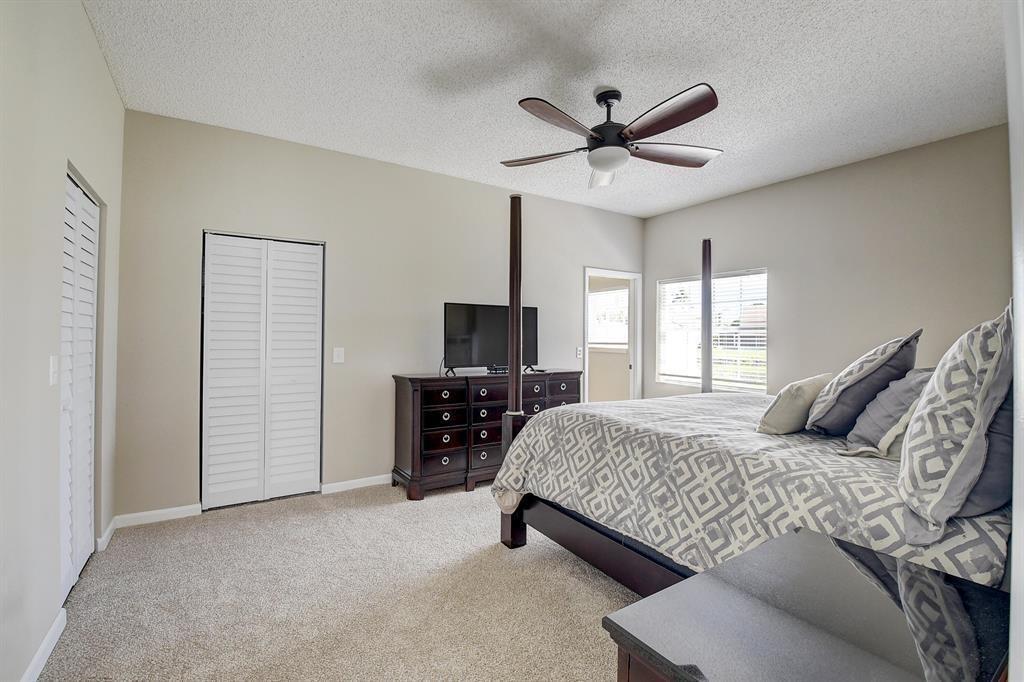 7769 Mansfield Hollow Road Delray Beach, FL 33446 - Photo 16 of 18 a bedroom with a bed and a flat screen tv