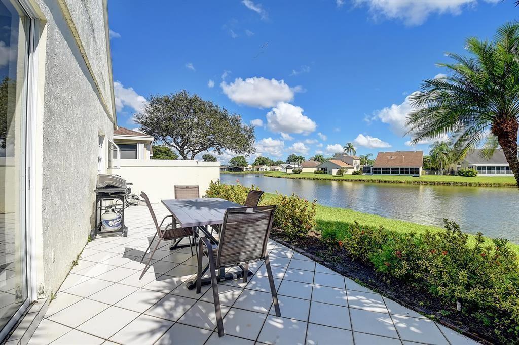 7769 Mansfield Hollow Road Delray Beach, FL 33446 - Photo 3 of 18 a view of a lake with table and chairs and potted plants