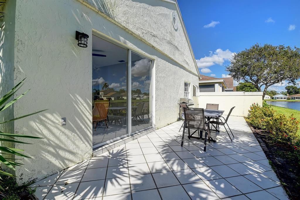 7769 Mansfield Hollow Road Delray Beach, FL 33446 - Photo 6 of 18 a view of a patio with table and chairs and potted plants