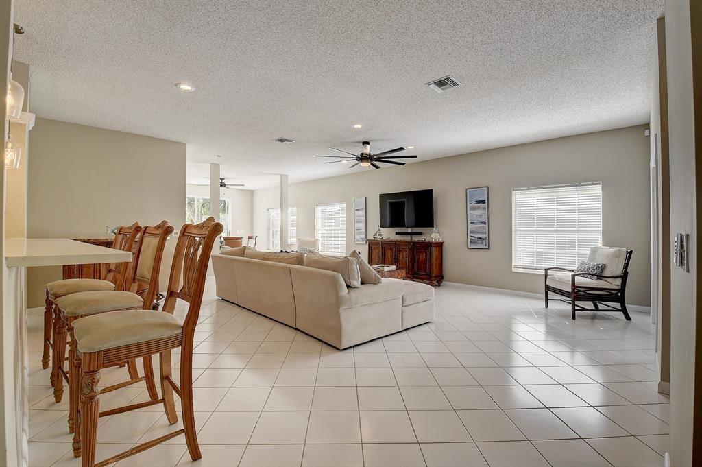 7769 Mansfield Hollow Road Delray Beach, FL 33446 - Photo 8 of 18 a living room with furniture a dining table and a piano table