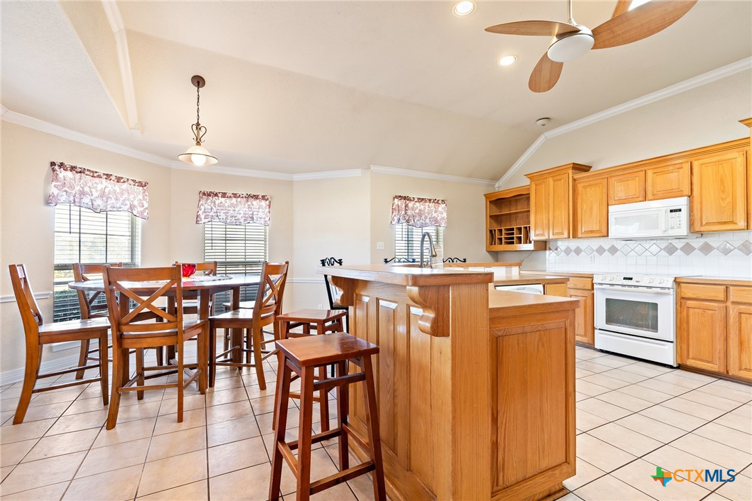 155 Western Ridge Road Gatesville, TX 76528 - Photo 14 of 26 a dining hall with stainless steel appliances kitchen island granite countertop a dining table chairs and view living room