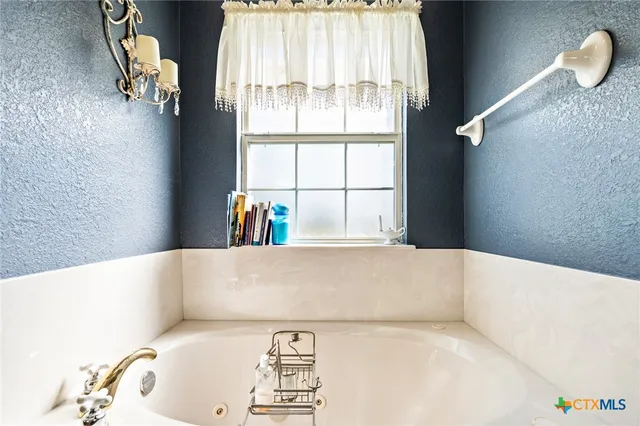 a spacious bathroom with a sink mirror and a bathtub