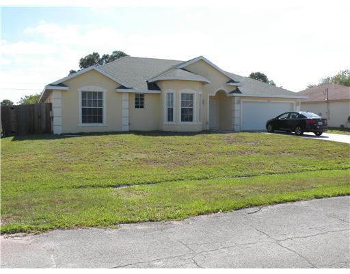4625 Southwest Inagua Street Port St. Lucie, FL 34953 - Photo 1 of 9 a view of a house with a yard and garage