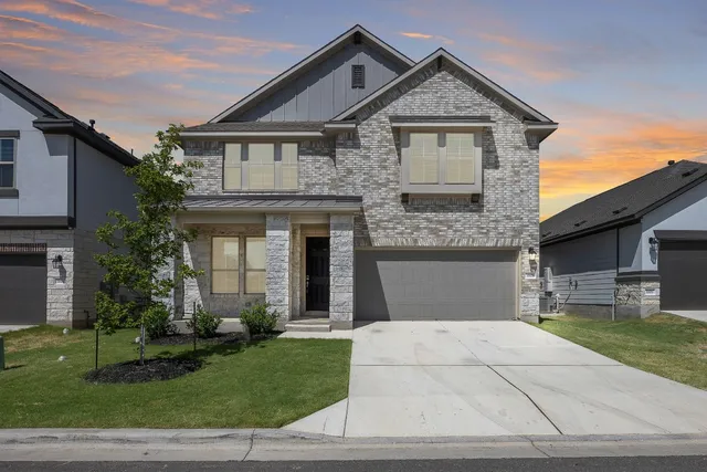 a front view of a house with a garden and plants