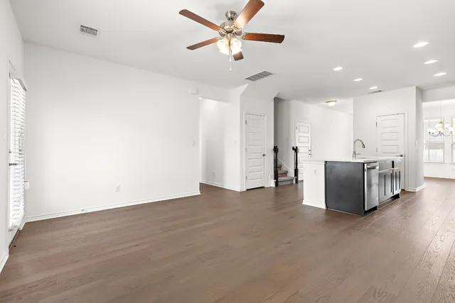 a view of a kitchen with a sink and a chandelier fan