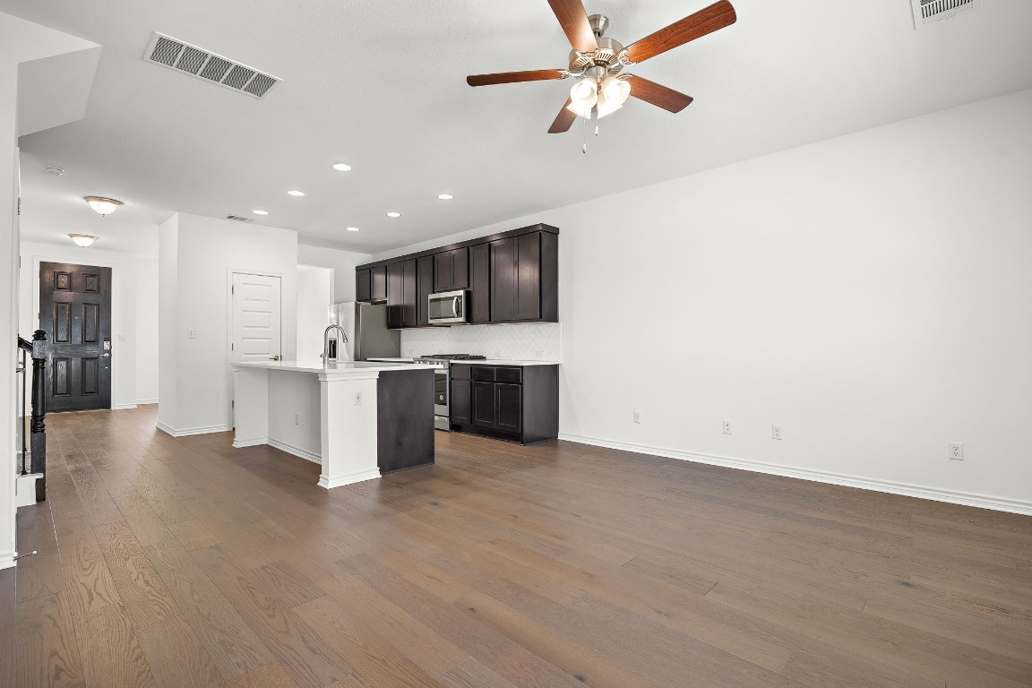1817 Turtle Bay Loop Leander, TX 78641 - Photo 15 of 38 a view of kitchen with stainless steel appliances kitchen island wooden floor and chandelier