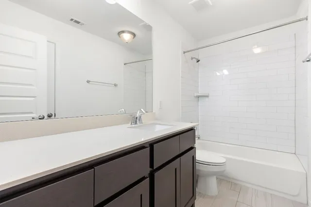 a bathroom with a sink a toilet a mirror and shower