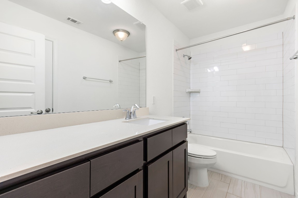 1817 Turtle Bay Loop Leander, TX 78641 - Photo 19 of 38 a bathroom with a sink a toilet a mirror and shower