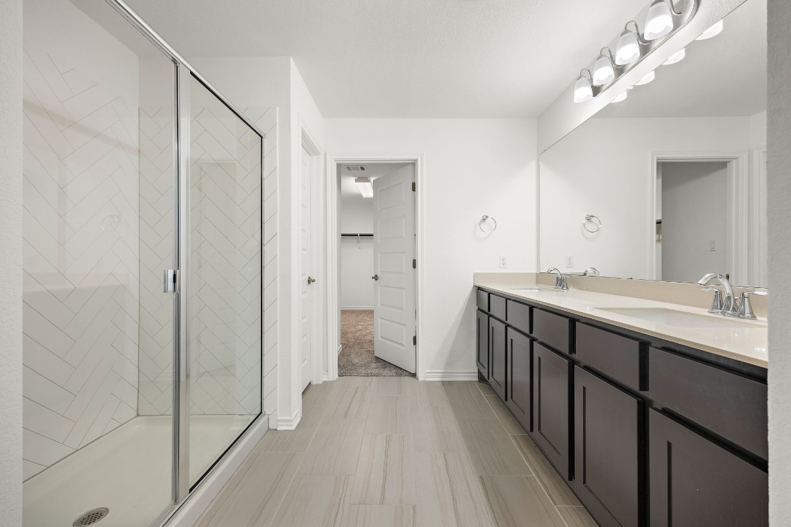 1817 Turtle Bay Loop Leander, TX 78641 - Photo 22 of 38 a spacious bathroom with a double vanity sink and a mirror