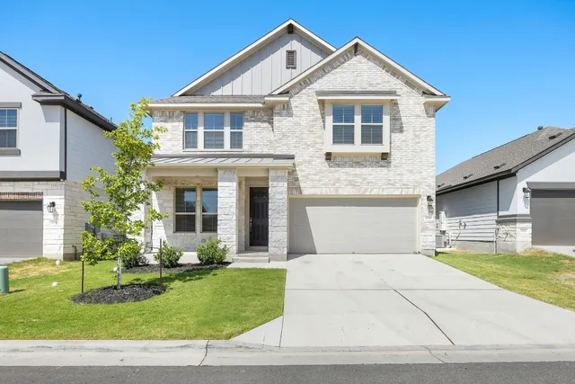 a front view of a house with a yard and garage