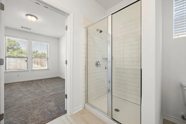 a bathroom with a shower and a glass door