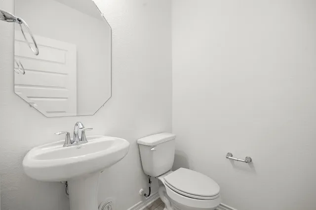 a bathroom with a sink a toilet and mirror