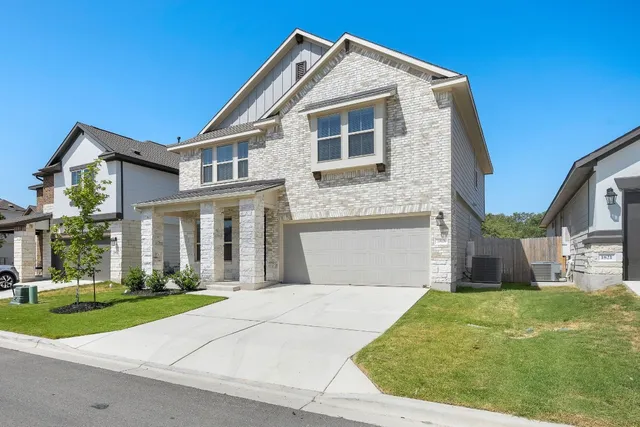 a front view of a house with a yard and potted plants