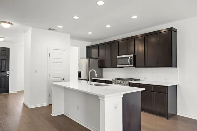a kitchen with stainless steel appliances a refrigerator stove and sink