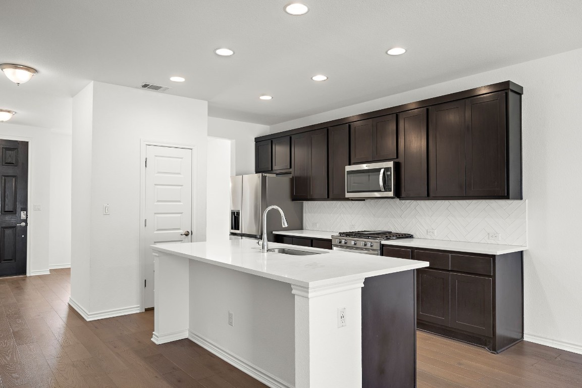 1817 Turtle Bay Loop Leander, TX 78641 - Photo 5 of 38 a kitchen with stainless steel appliances a refrigerator stove and sink
