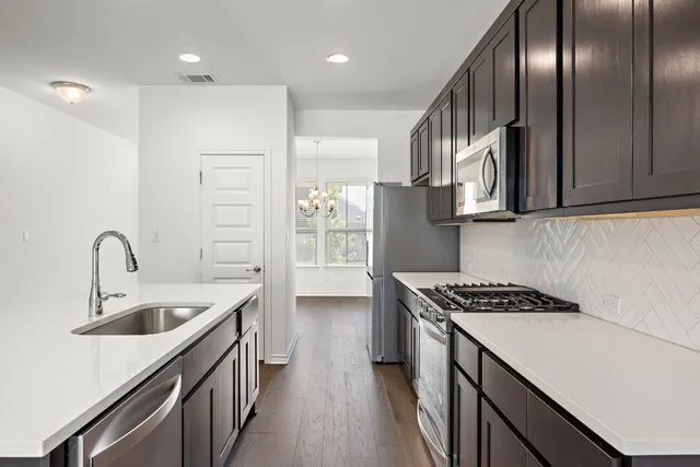 a kitchen with stainless steel appliances granite countertop a sink stove and cabinets