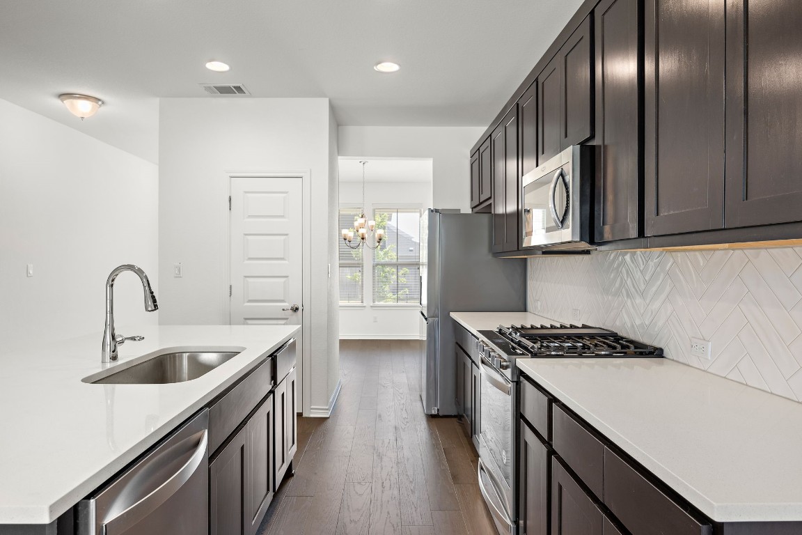 1817 Turtle Bay Loop Leander, TX 78641 - Photo 8 of 38 a kitchen with stainless steel appliances granite countertop a sink stove and cabinets