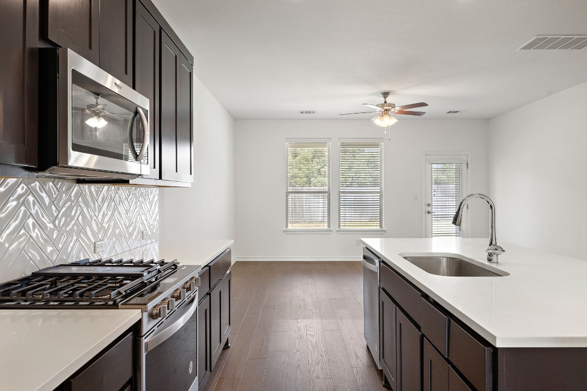 1817 Turtle Bay Loop Leander, TX 78641 - Photo 10 of 38 a kitchen with stainless steel appliances granite countertop a sink stove and cabinets
