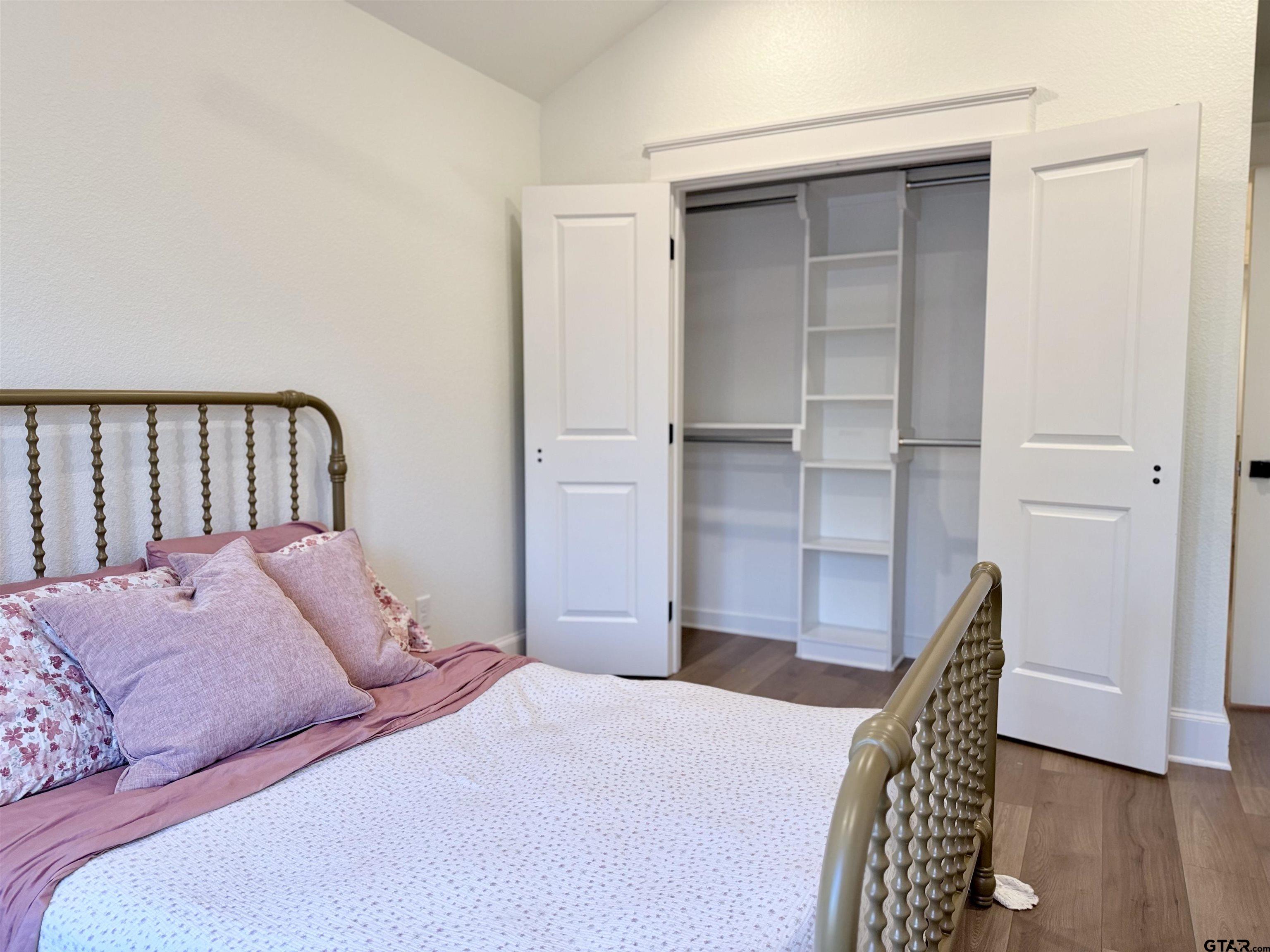 413 Dallas Street Winona, TX 75792 - Photo 26 of 33 a bedroom with a bed and wooden floor