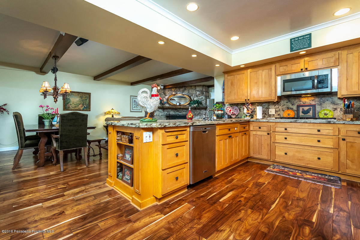 9624 Creemore Drive Tujunga, CA 91042 - Photo 18 of 56 a kitchen with stainless steel appliances kitchen island granite countertop a stove a sink and a refrigerator