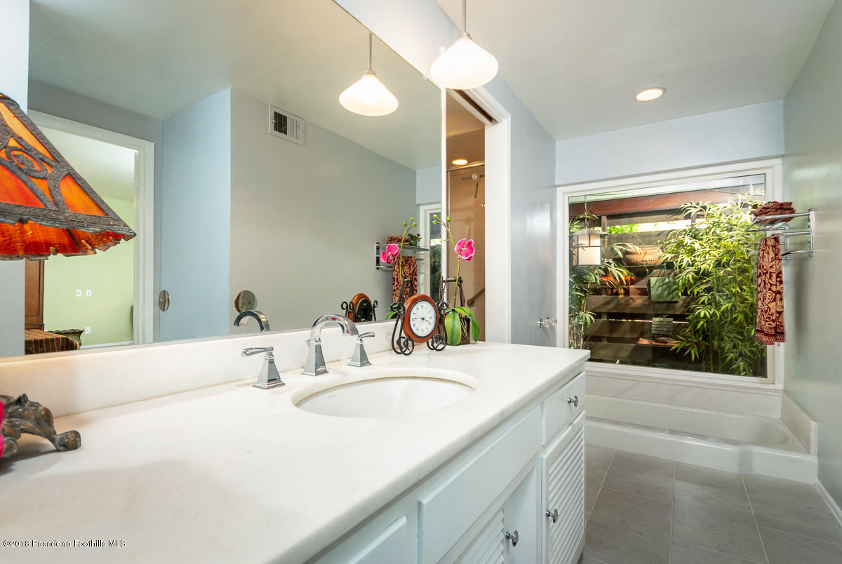 9624 Creemore Drive Tujunga, CA 91042 - Photo 25 of 56 a bathroom with a granite countertop sink and a large mirror