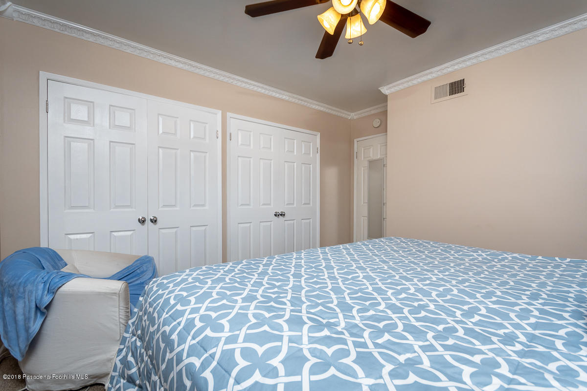 9624 Creemore Drive Tujunga, CA 91042 - Photo 30 of 56 a bedroom with a bed and a chandelier fan