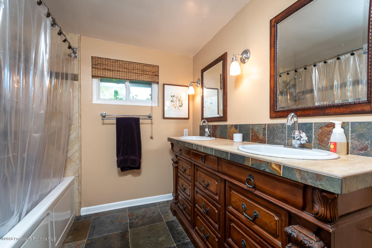 9624 Creemore Drive Tujunga, CA 91042 - Photo 34 of 56 a spacious bathroom with a granite countertop sink and a mirror