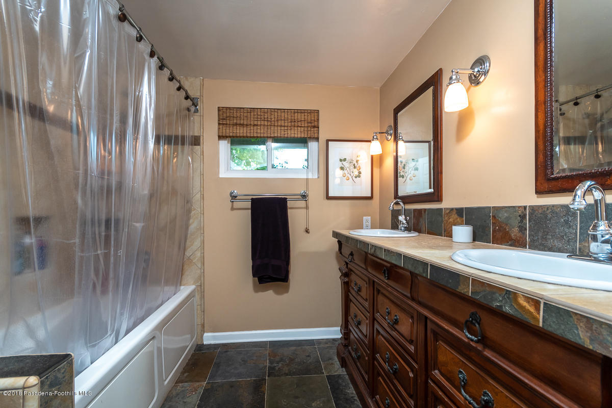 9624 Creemore Drive Tujunga, CA 91042 - Photo 35 of 56 a bathroom with granite countertop a sink and a mirror