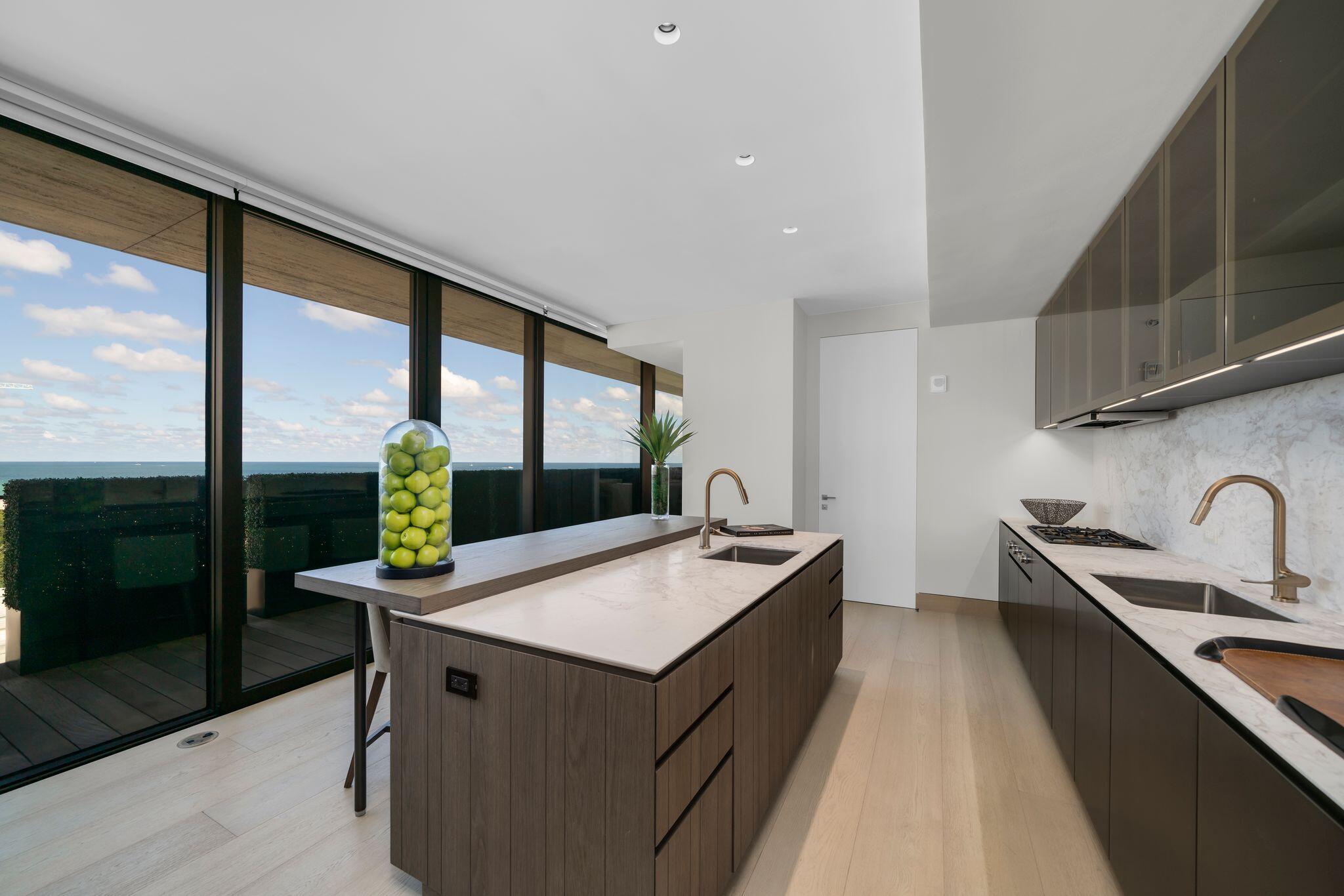 8955 Collins Avenue, Unit LPH Surfside, FL 33154 - Photo 16 of 40 a kitchen with sink refrigerator and stove