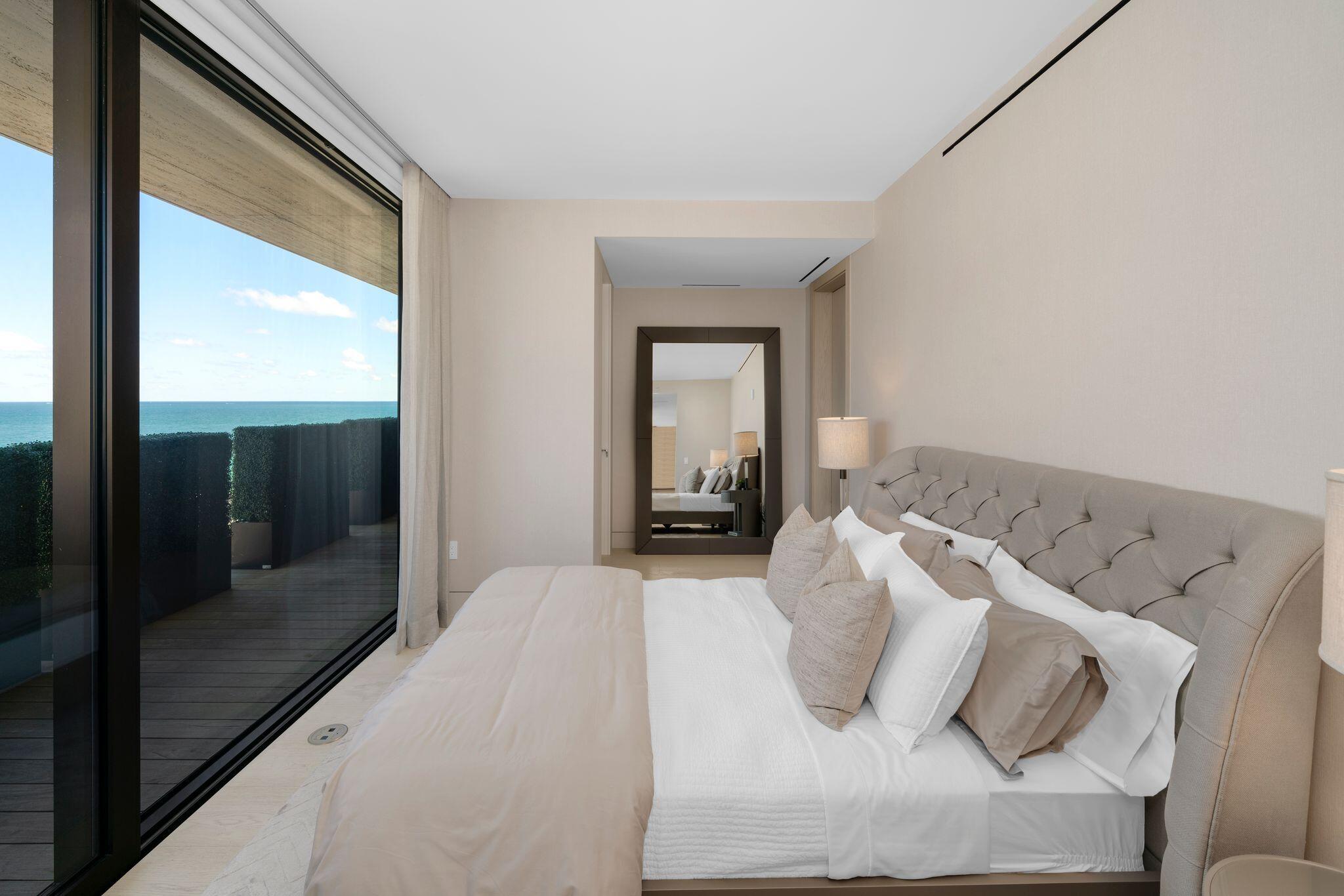 8955 Collins Avenue, Unit LPH Surfside, FL 33154 - Photo 28 of 40 a bedroom with a bed and glass door