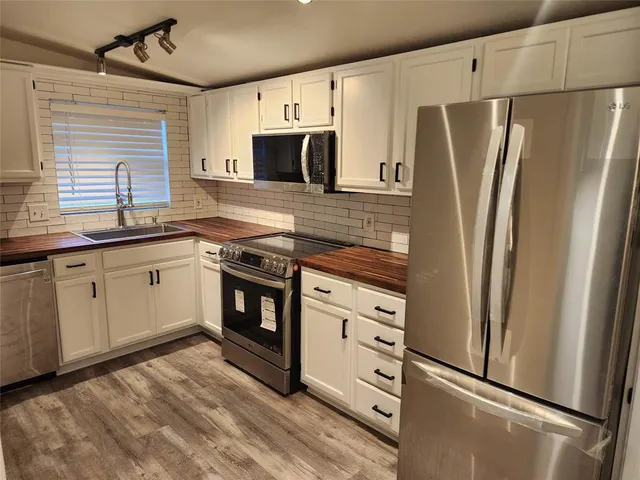 a kitchen with stainless steel appliances a refrigerator stove and sink