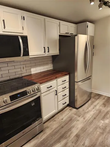 a kitchen with granite countertop white cabinets and stainless steel appliances