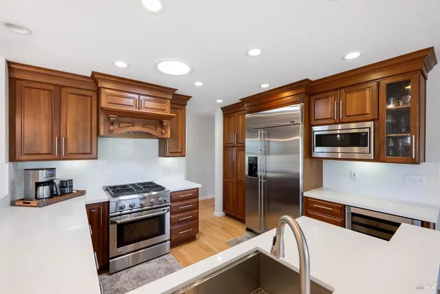 a open kitchen with a sink a counter top space stainless steel appliances and a chandelier