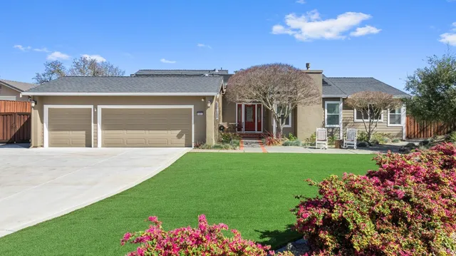 a front view of a house with a garden and plants