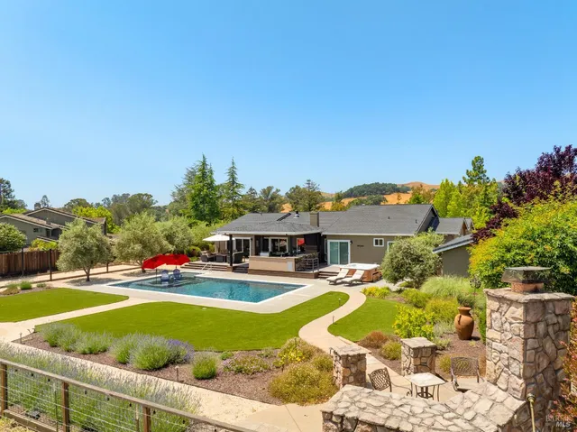 a view of a swimming pool with outdoor seating and plants