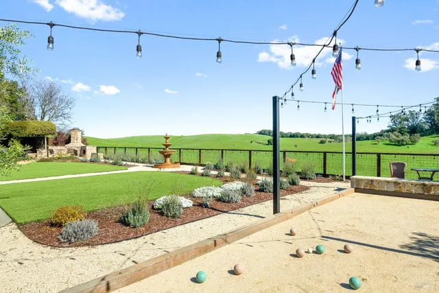 a swimming pool view with a seating space and a garden view
