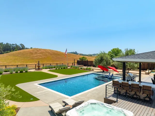 a swimming pool with outdoor seating and garden