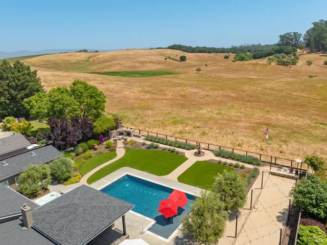a view of a patio with a table and chairs under an umbrella