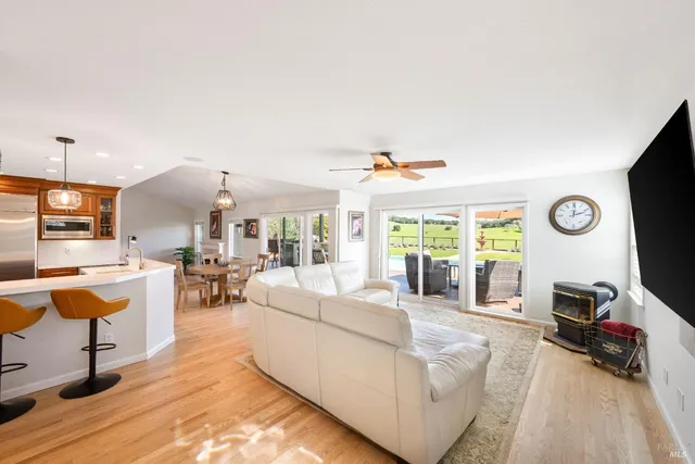 a living room with stainless steel appliances kitchen island a table and chairs in it