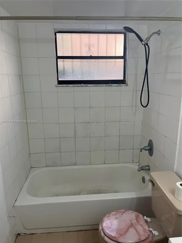 a bathroom with a toilet bathtub and shower