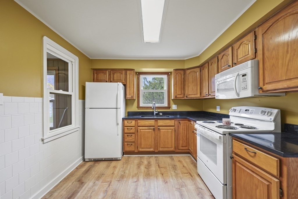 227 Protection North Adams, MA 01247 - Photo 11 of 25 a kitchen with a refrigerator a stove a sink dishwasher and wooden cabinets with wooden floor