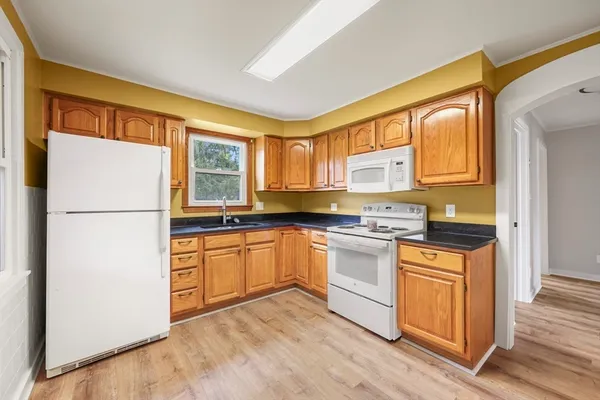 a kitchen with stainless steel appliances granite countertop a refrigerator a stove a sink and a microwave