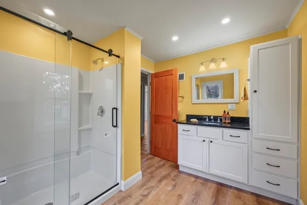 a bathroom with a granite countertop sink a mirror a shower and a bathtub