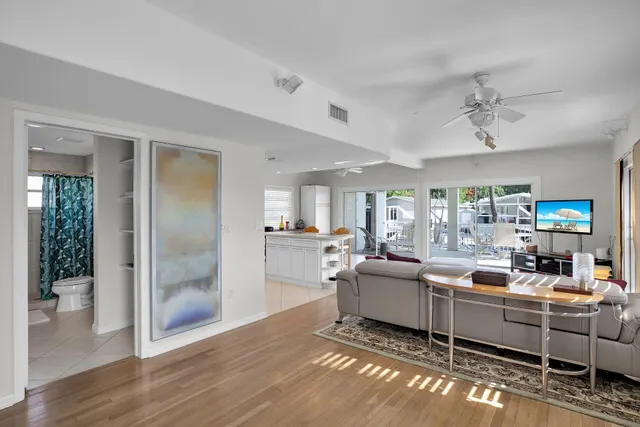 a living room with furniture a chandelier and a wooden floor