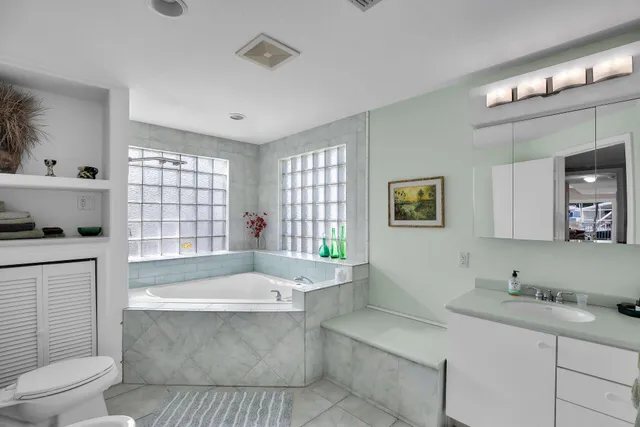 a spacious bathroom with a tub sink and mirror